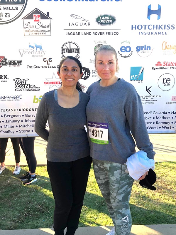 Pair posing in front of community event poster